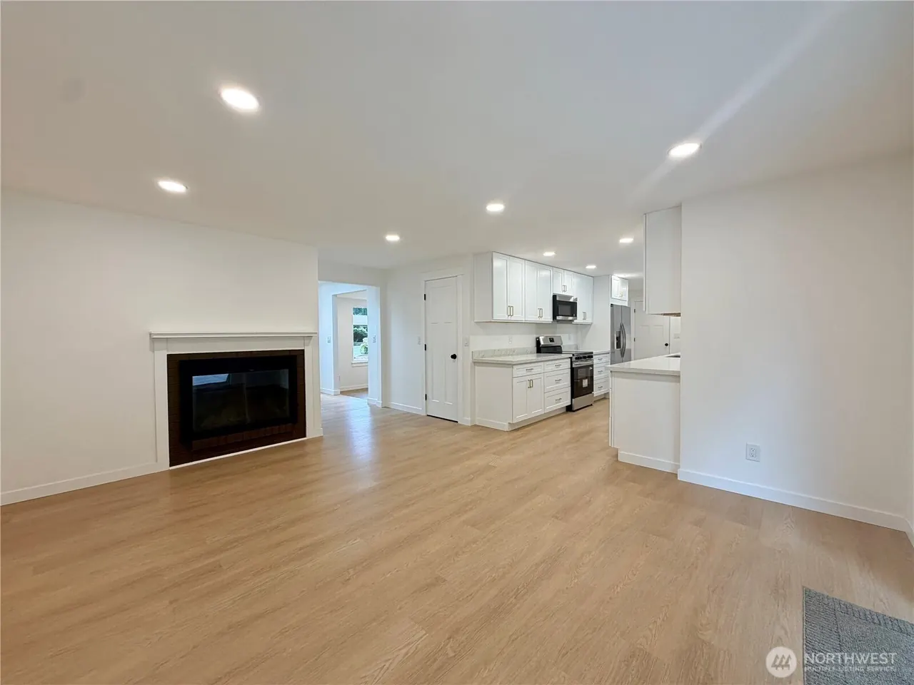 Open-concept living space with fireplace and kitchen